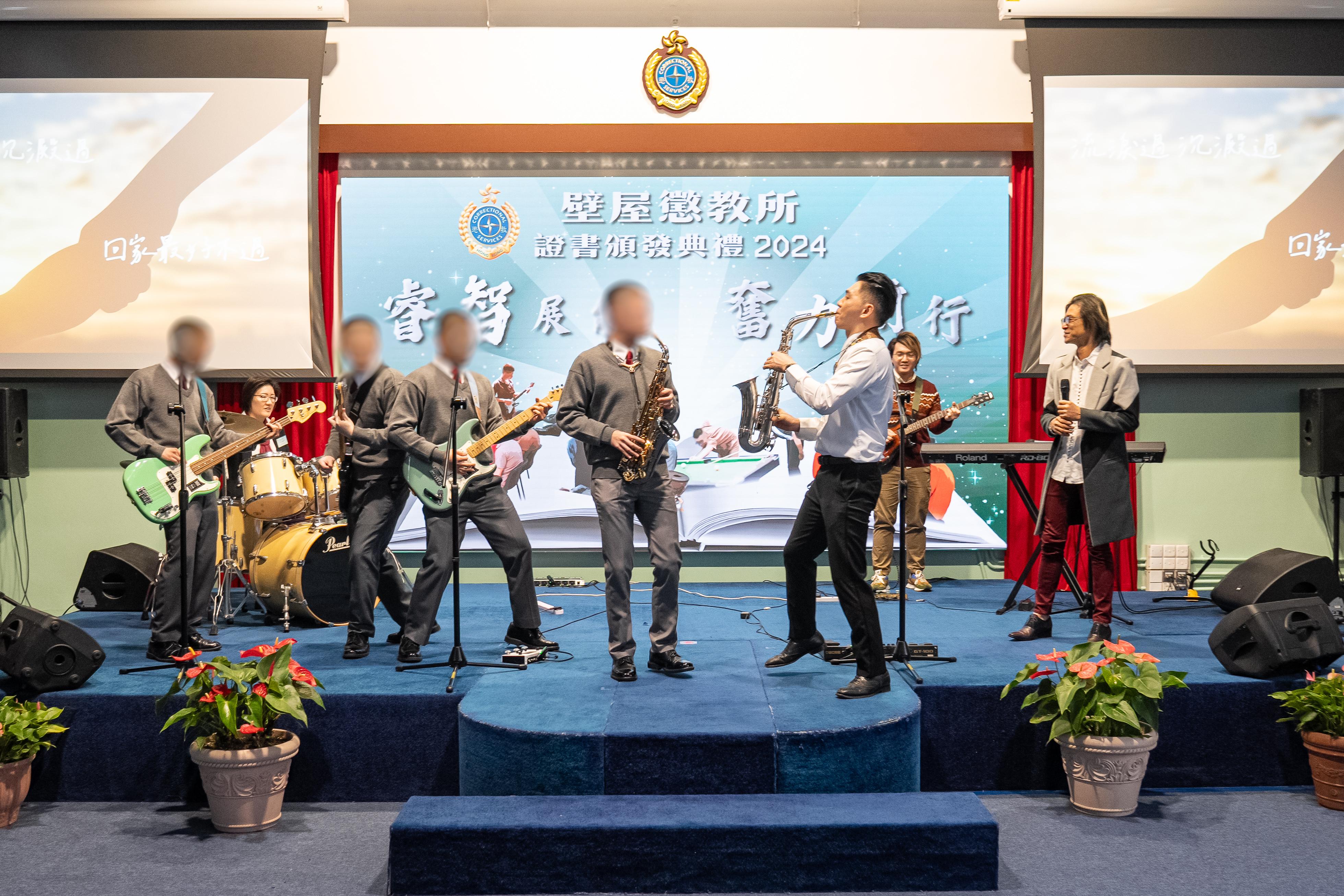 Young persons in custody at Pik Uk Correctional Institution of the Correctional Services Department were presented with certificates at a ceremony today (December 5) in recognition of their efforts and achievements in studies and vocational examinations. Photo shows a music performance by volunteer tutor and saxophonist Timothy Sun (front row, right), and a band composed of persons in custody.